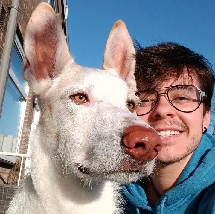 Alex y su perro de asistencia Maylo al aire libre.